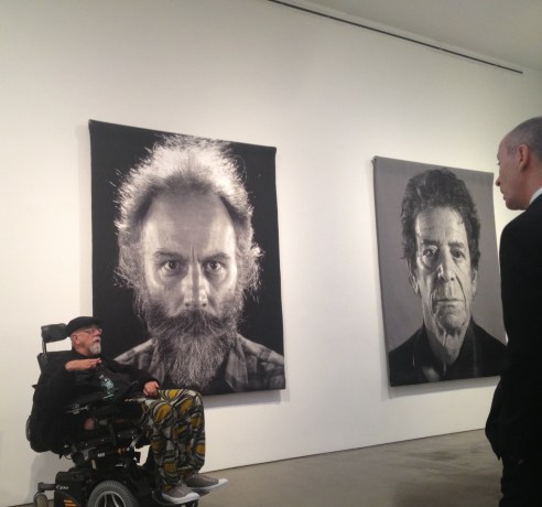 Chuck Close in 2012 with Tapestry portraits of Lucas Samaras (left) and Lou Reed (right).